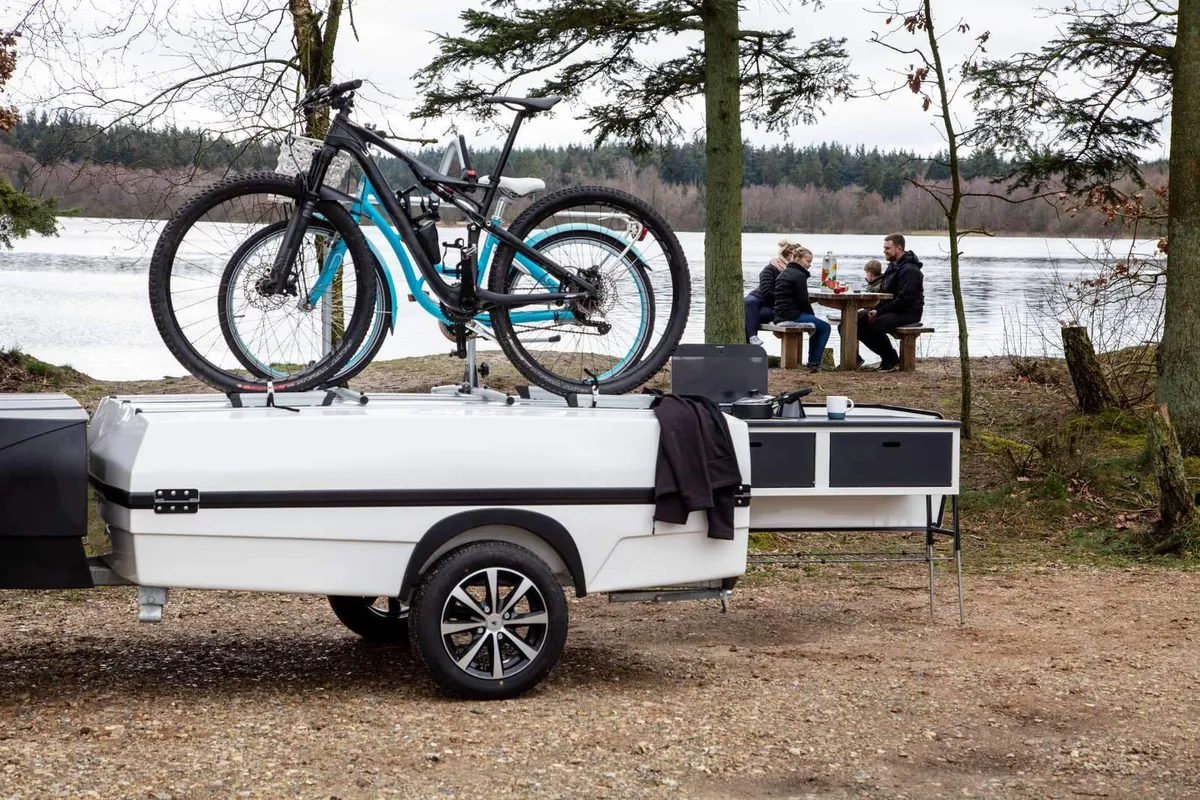 Camp-let med cyklar på cykelhållaren vid en sjö